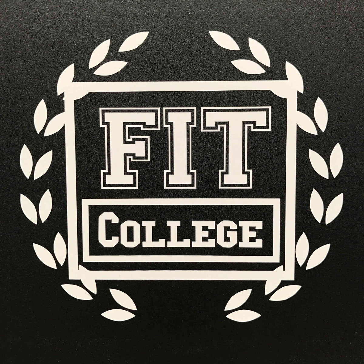 White FIT College lettering logo with wreath decal on black surface.